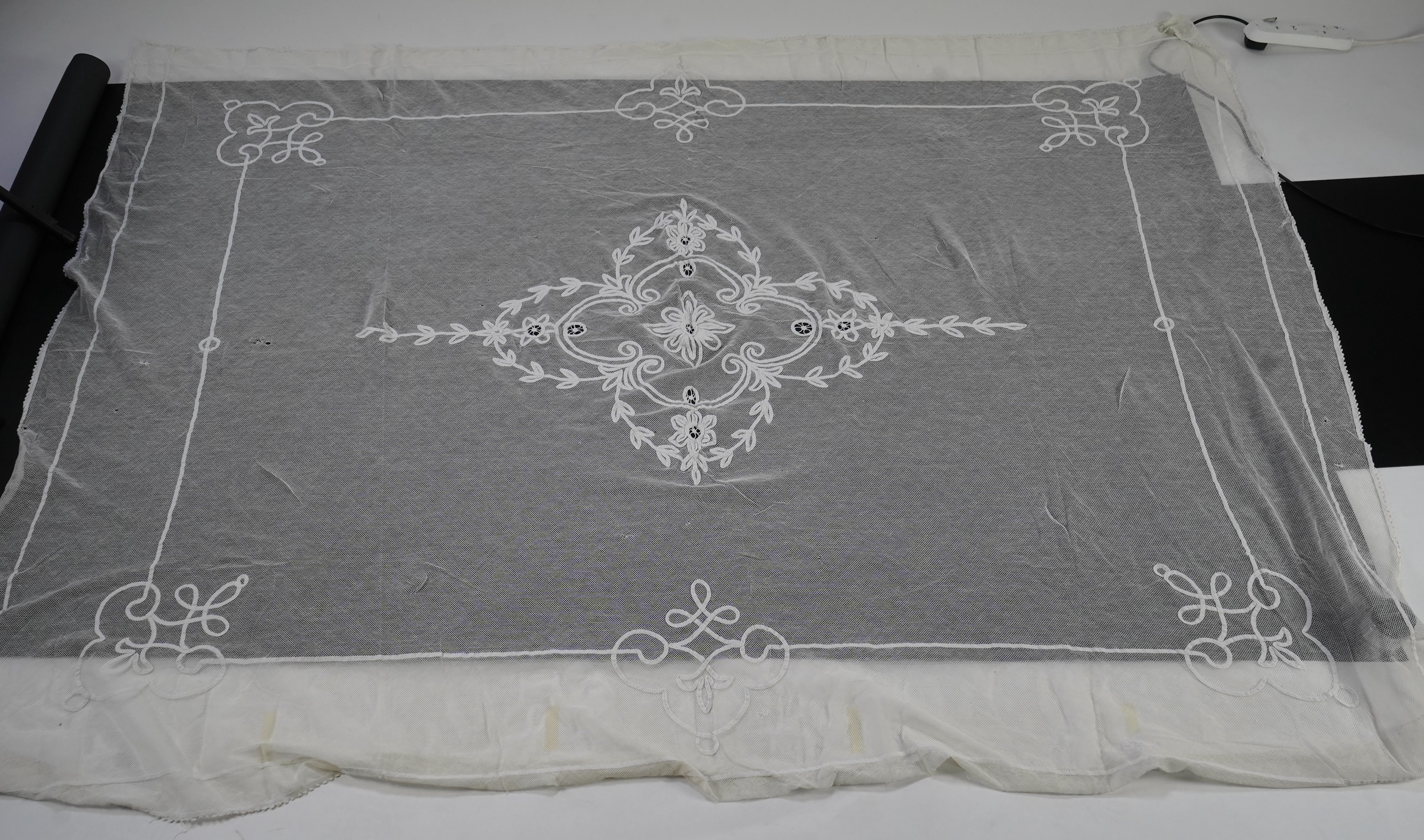 A white tape lace on net bed cover, a cream lace needle run panel, three Brussels bobbin lace collars, a lappet and two beaded tea pot covers, bed cover 200cm x 250cm. Condition - the bedcover has damage to the netting,